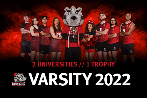 Male and female students in red and black sports uniforms standing with arms crossed either side of a man in the City Wolfpack mascot costume. Two universities, one trophy - Varsity 2022.